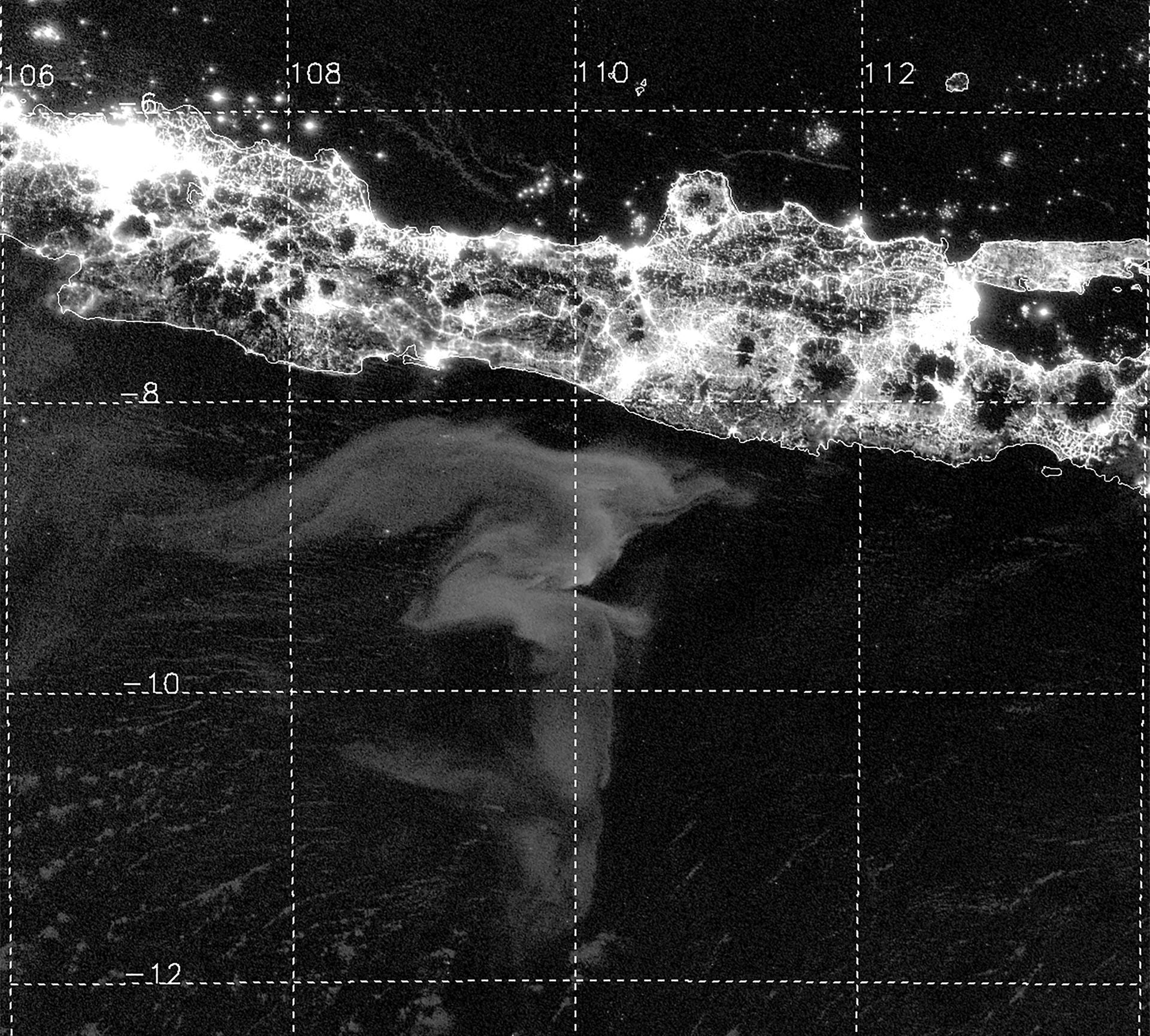 Night vision image of Java coastline with large light gray shape on the ocean's surface